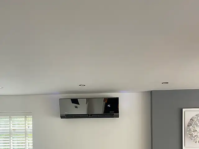 A black gloss designer air conditioning unit in a living room, the kind of air conditioning we fit for homes in Redbridge