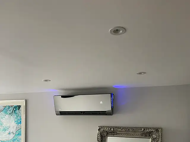 Domestic air conditioning in Hackney A quiet mirror-finish air conditioning unit above a bed, the kind of air conditioning we fit for homes in Hackney