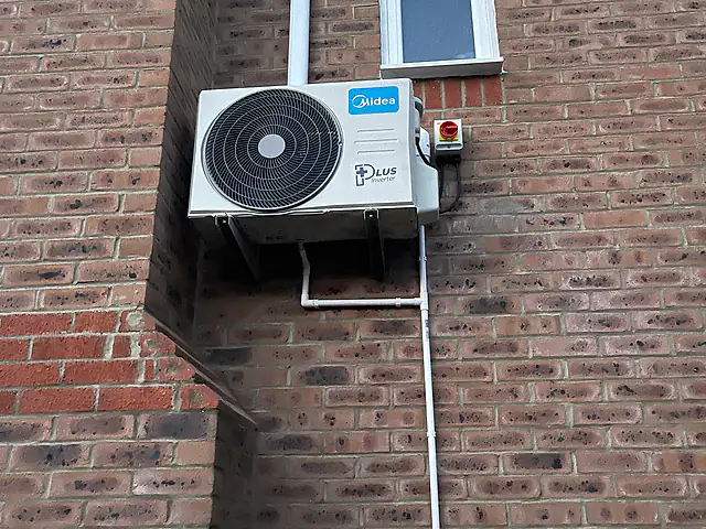 Air Conditioning Replacement in London: an outdoor condenser on a wall bracket with neat pipe covers